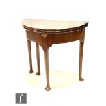 A George III mahogany demi lune double fold over tea table concealing an interior, plain frieze on