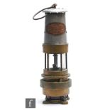 A brass miner's lamp with aluminium chimney and plaque named Naylor Spiralarm type ?M?, by L H