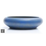 A large Ruskin Pottery float bowl decorated in a mottled and fissured blue over a dark green ground,