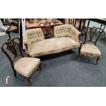 A Victorian carved mahogany three piece drawing room suite comprising a three seater button back
