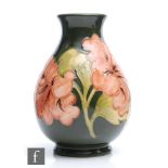 A Moorcroft Pottery footed baluster vase decorated in the Hibiscus pattern with coral flowers