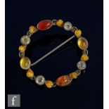 A silver and enamel brooch, circular body with applied wirework leaves enamelled orange and red, set