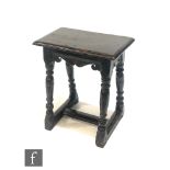 A 17th Century and later carved oak joint stool, the later top over a plain and carved scroll frieze