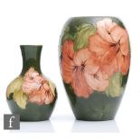 Two Moorcroft vases of varying form decorated in the Hibiscus pattern with coral flowers against a