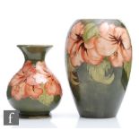 Two Moorcroft vases of varying form decorated in the Hibiscus pattern with coral flowers against a