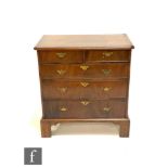 A small George III style crossbanded chest of two short and three long drawers, brass fret drop