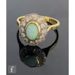 An 18ct hallmarked opal and diamond cluster ring, central collar set oval opal, length 7.5mm, within