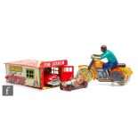 A Marx tinplate automatic fire station with fire chief car, a clockwork motor cycle rider and a