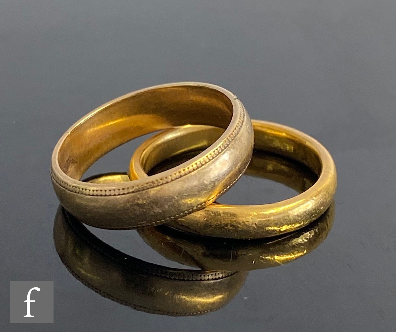 A 22ct hallmarked D shaped wedding ring, weight 4.3g, with a similar 9ct example, weight 3.1g. (2)