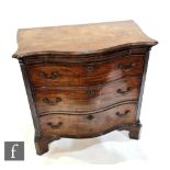 A George III style mahogany serpentine chest of three long drawers below a leather inset brushing
