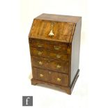 An 18th Century walnut feather and cross banded bureau of small proportions, the fitted interior