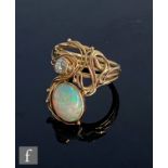 A 9ct hallmarked Art Nouveau style opal and diamond two stone ring, oval collar set opal, length