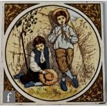 A 6 inch polychrome tile decorated with a scene of two shepherd boys, one playing a pipe the other