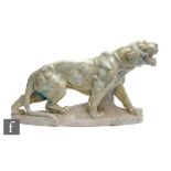 A 20th Century soapstone study of a lioness, on an oval plinth base, indistinctly signed, length