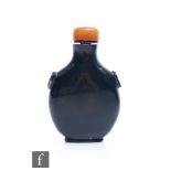 A Chinese 19th Century opaque black glass snuff bottle of flattened circular form, with ring handles