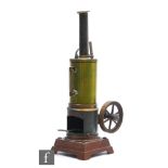 A 1920s German vertical steam engine with brass boiler and chimney, single oscillating flywheel,