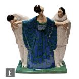 A 1930s French Art Deco model of a lady stood dressed in a blue and green gown with her arms