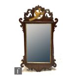 A 20th Century Chippendale style mahogany fret carved wall mirror, the pierced pediment carved