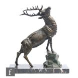 A 20th Century bronzed spelter study of a stag standing on a rocky out crop, on a black veined