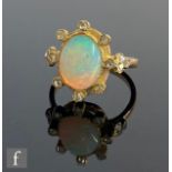 A 18ct opal and diamond cluster ring, central collar set oval opal, length 10mm, within a border