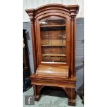 A 19th Century mahogany bookcase, the moulded edge arch top over a glazed door flanked by turned