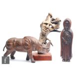 A 20th Century carved wooden study of a Rhinoceros with leather tail and ears, length 46cm, together