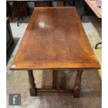A 17th Century style oak refectory table, the cleated plank top over a plain frieze, on turned