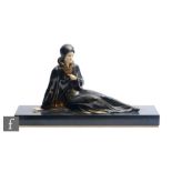 An Art Deco style painted spelter figure of a reclining female in flowing dress, on black