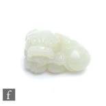 A Chinese 20th Century jade 'Qilin' pebble carving, the pale green stone carved in high relief