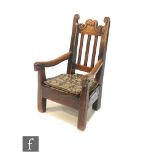 An early 19th Century ash child?s chair, the scroll undulating top rail over a pierced splat and
