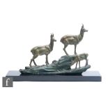 A 20th Century French group of three bronzed spelter deer including a fawn, on coloured rocky out