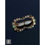 A late 19th Century gold diamond and opal set brooch with two central pear shaped opals within an