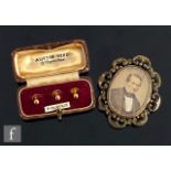 A cased set of three 9ct dress studs, total weight 1.3g, with a gilt metal memorial brooch. (2)