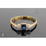 An early 20th Century 18ct sapphire and diamond three stone ring, central emerald cut sapphire