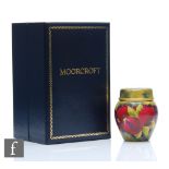 A boxed Moorcroft enamels ginger jar and cover decorated in the Pomegranate pattern, printed