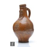 An 18th Century or earlier Bartmann or Bellarmine jug, the salt glazed body and neck with a