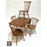 A set of four Ercol model 376 Windsor or 'candlestick' elm and beech dining chairs, designed by