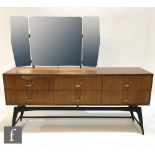 A 1960s teak dressing table by Meredew Furniture, with a triple mirror above an arrangement of six