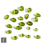Twenty loose cut and polished peridot to include oval, pear and round examples, length of largest