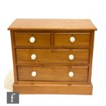 A small Victorian pine dressing chest of two short and two long drawers, white ceramic handles, on a