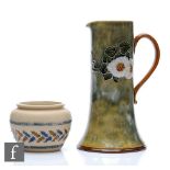 An early 20th Century Royal Doulton jug decorated with tubed flowers and foliage over a mottle green