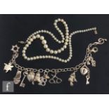 A modern silver charm bracelet with various charms attached, terminating in lobster clasp,