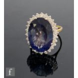 An 18ct hallmarked blueberry quartz and diamond cluster ring, central oval quartz, length 18mm,