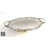 A hallmarked silver twin handled oval pedestal comport, plain well with pierced foliate and fruiting