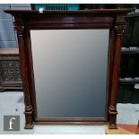 A large Edwardian mahogany classical style overmantel mirror, the bevelled plate flanked by a pair