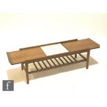 A 1960s teak coffee table of rectangular form, the top with metamorphic action opening to reveal a