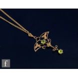 An early 20th Century 9ct open work pendant set with two peridot, length 4cm, suspended from a later