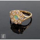 A 9ct hallmarked opal and diamond daisy cluster ring, central opal within a border of eight