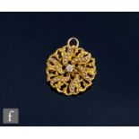 A 14ct circular pendant/brooch set with central diamond within six radiating rows of six seed