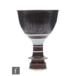 A mid 20th Century studio pottery goblet or chalice decorated in a brown dribble glaze with a shaped
